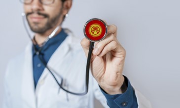 Doctor holding stethoscope with Kyrgyzstan flag. Kyrgyzstan health and care concept, Kyrgyzstan
