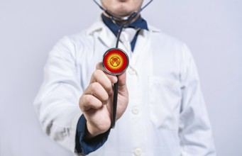 Doctor hands holding stethoscope with Kyrgyzstan flag. Kyrgyzstan health and care concept