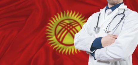 Kyrgyzstan healthcare concept. Male doctor on Kyrgyzstan flag. Doctor with crossed arms on