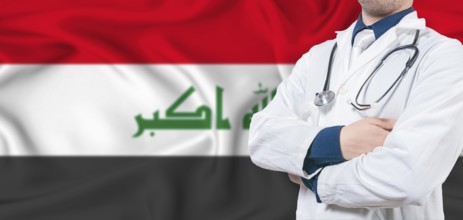 Iraq healthcare concept. Male doctor on Iraq flag. Doctor with crossed arms on Iraq flag