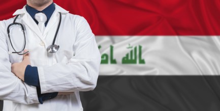 Male doctor with stethoscope on Iraq flag. Doctor holding stethoscope on Iraq flag