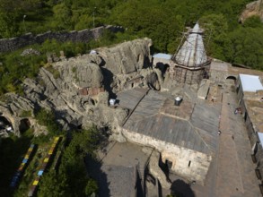 Old monastery in rocky landscape, surrounded by green nature, parts under renovation by