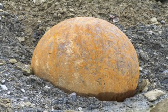Rusty metal ball used for stone crushing in stony back