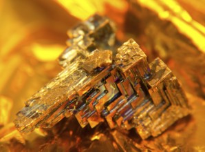 A multicolored Bismuth crystal, warm illuminated in golden back