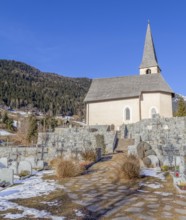 Church and cemetery in a village named St Felix in South Tyrol at winter time