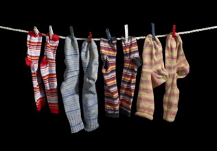 Clothesline with some multicolored sox fixed with clothes pins in black back