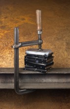 Some hard disk drives compressed with a screw clampin rusty back