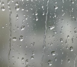 Detail of roll off raindrops on window glass