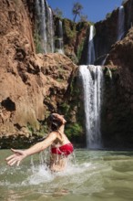 Beautiful woman bathing under a waterfall Ouzoud in Morocco