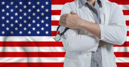Doctor with stethoscope on arm with American flag behind. National health system of United States,