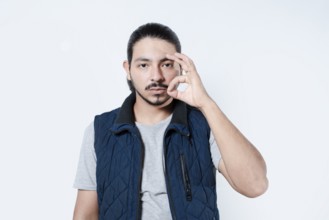 Serious man making gesture of approval. Young man making a circle with his fingers