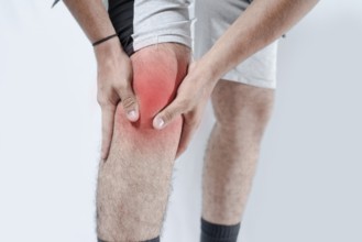 Close-up of sore knee in red isolated. Sore knee on white background