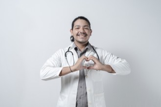 Smiling doctor making heart symbol on isolated