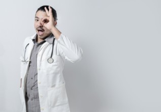 Doctor looking through his fingers. Young doctor with open mouth