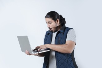 Man surprised looking at the computer he is holding on isolated