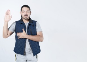 Serious man taking oath on isolated background. Young man taking an oath on white background