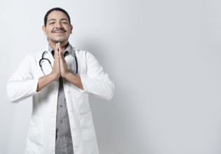Smiling doctor praying on isolated. Young doctor praying