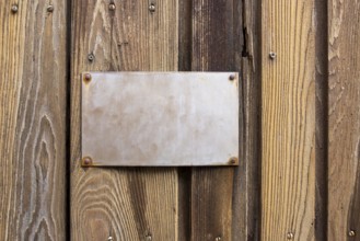 Old metallic sign on wooden board