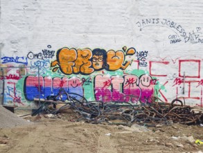 A hodgepodge of colourful graffiti adorns a white wall with cables on the floor Mariahilferstrasse