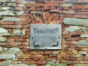 Brick wall with closed wooden window, aged and with a rough texture Styria Austria