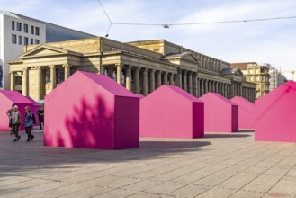 Twelve houses in bright magenta stand on Stuttgart's Schlossplatz in front of the art museum. The