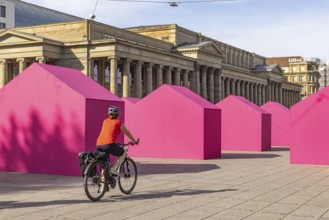 Twelve houses in bright magenta stand on Stuttgart's Schlossplatz in front of the art museum. The