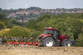 Tractor ploughs up a harvested grain field, south of Billerbeck in Münsterland, North