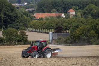 Tractor ploughs up a harvested grain field, south of Billerbeck in Münsterland, North