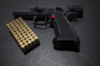 Modern Elegant Sport Handgun with Gas Pedal and Skirt and Bullet on Grey Background in Switzerland