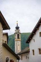 Beautiful Street in Old Town with Mountain View and Church Tower in a Summer Day in Samedan,