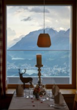 Beautiful Restaurant Table Window View over Alpine Lake and Swiss Alps and Cityscape in Sunset and