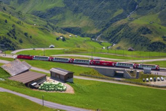 Beautiful View over Mountain Valley with Mountain Road and Railroad Station with Glacier Express