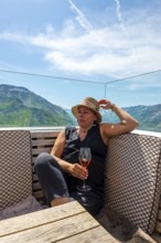 Woman Sitting in a Restaurant Terrasse with Mountain View in the Swiss Alps and Blue Sky with