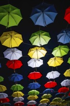 Many Illuminated Colorful Umbrellas Hanging Against Sky at Night in Switzerland