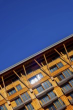Beautiful Modern Wood Facade Building with Balcony Against Blue Clear Sky in a Sunny Summer Day in
