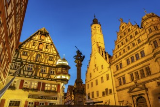 Georgsbrunnen, Marien-Apotheke, town hall and town hall tower in Rothenburg ob der Tauber at dusk,