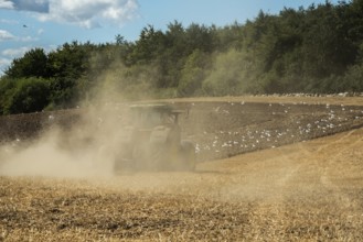 Autumn plowing with tractor on a dusty field in Borrie, Ystad municipality, Skåne county, Sweden,
