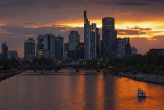 The sun breaks through the clouds behind the Frankfurt banking skyline shortly in front of setting,