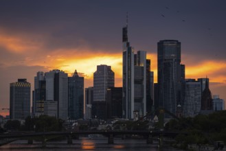 The sun breaks through the clouds behind the Frankfurt banking skyline shortly in front of setting,