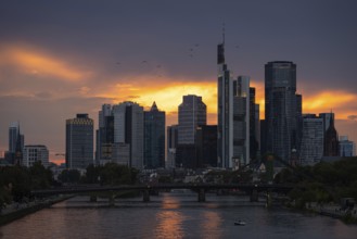 The sun breaks through the clouds behind the Frankfurt banking skyline shortly in front of setting,