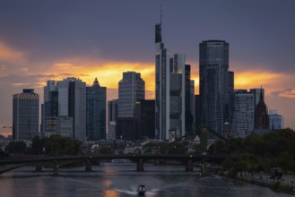 The sun breaks through the clouds behind the Frankfurt banking skyline shortly in front of setting,
