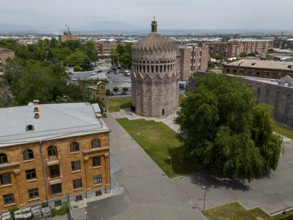 A round tower in an urban setting with surrounding trees and historic buildings, aerial view, Holy