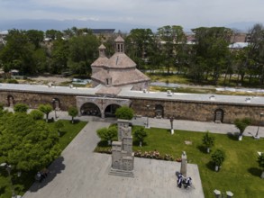 Historic church and monument in a green park with people in an urban setting, aerial view, St
