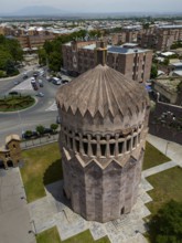 A tower with reddish stones, surrounded by streets and buildings, bird's eye view, aerial view,