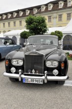 A black classic Rolls-Royce vintage car parked in front of a historic building, Retro Classics