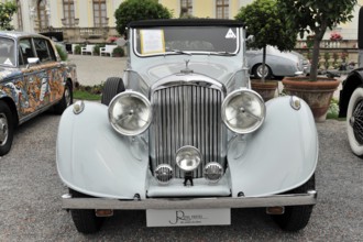 Bentley 4 ¼ Ltr. classic car, light grey convertible with open top in front of a historic building,