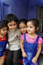 Udaipur, Rajasthan, North India, Asia, Four children pose close to each other, smiling and showing