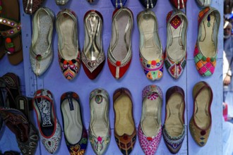 Udaipur, Rajasthan, North India, Asia, Colourful handmade shoes with traditional patterns on a wall
