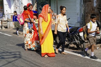 Udaipur, Rajasthan, North India, Asia, Women in colourful saris and children walking along a busy