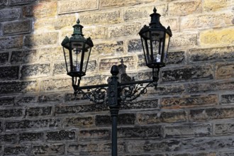 Prague, Czech Republic, Europe, vintage-style wall lantern casts shadows on a stone wall